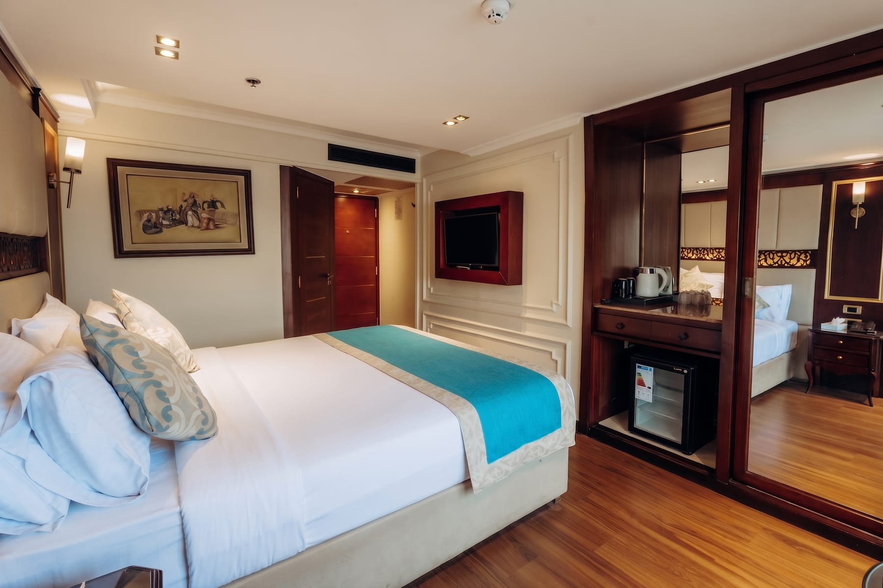 Elegant cabin aboard the M/S City and Sea Adonis with a large bed and wooden furnishings.