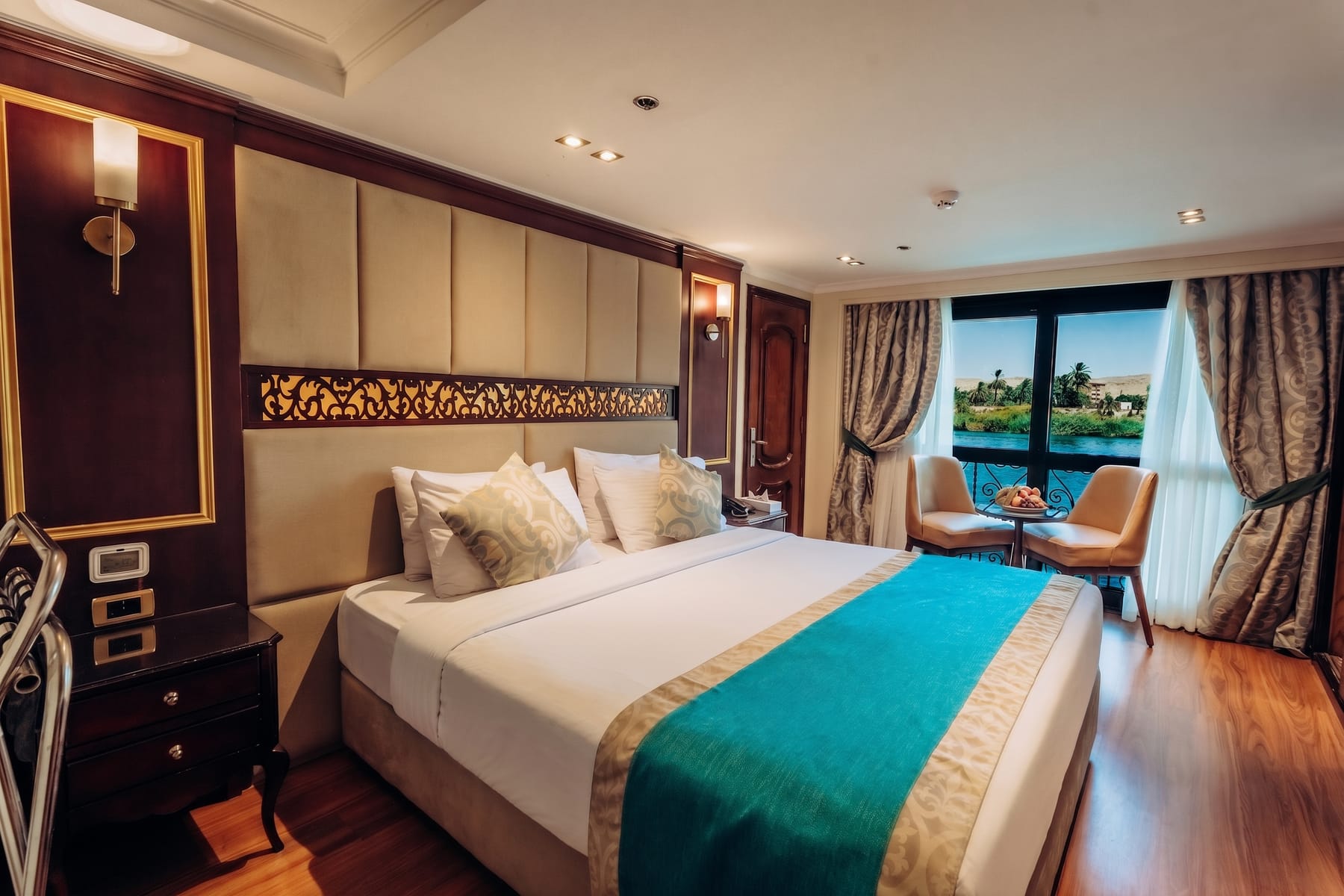 Elegant cabin aboard the M/S City and Sea Adonis with a view of the Nile through a French balcony.